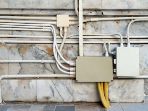 electrical junction boxes with plastic pipe connection on marble wall background