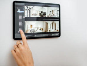Controlling home with video cameras and digital tablet. Concept of remote video surveillance over the internet with smart touch screen devices
